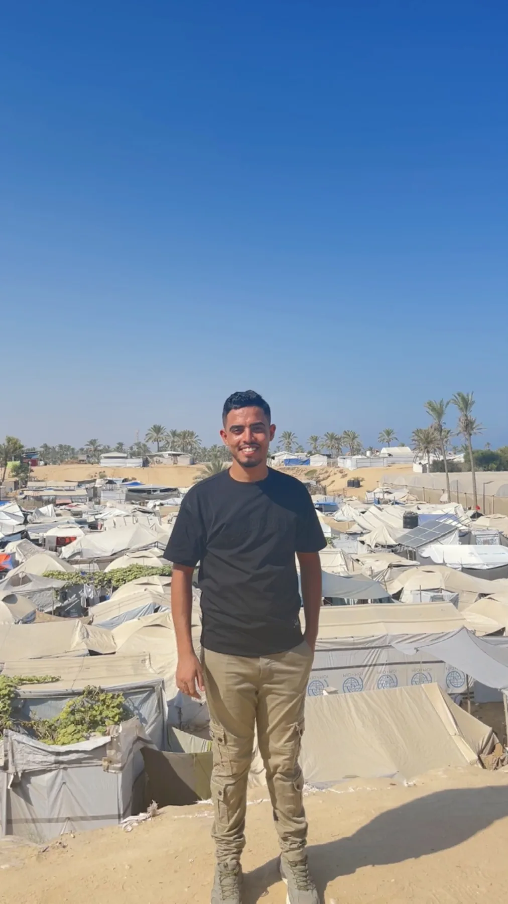 Field organizer standing above a displacement camp in Gaza